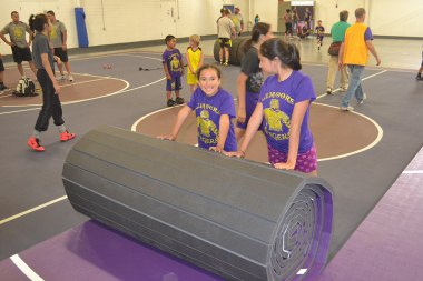 A pair of PAL participants roll up their new mat.